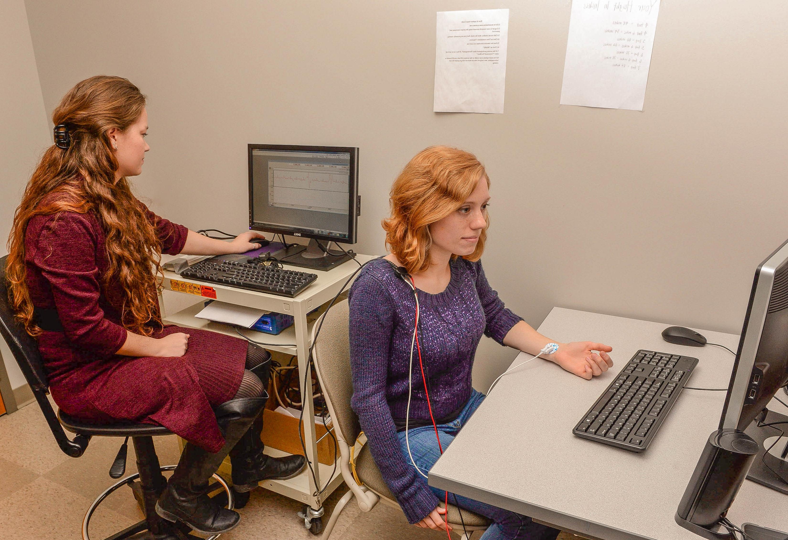 Two female students sitting working on computers in a classroom